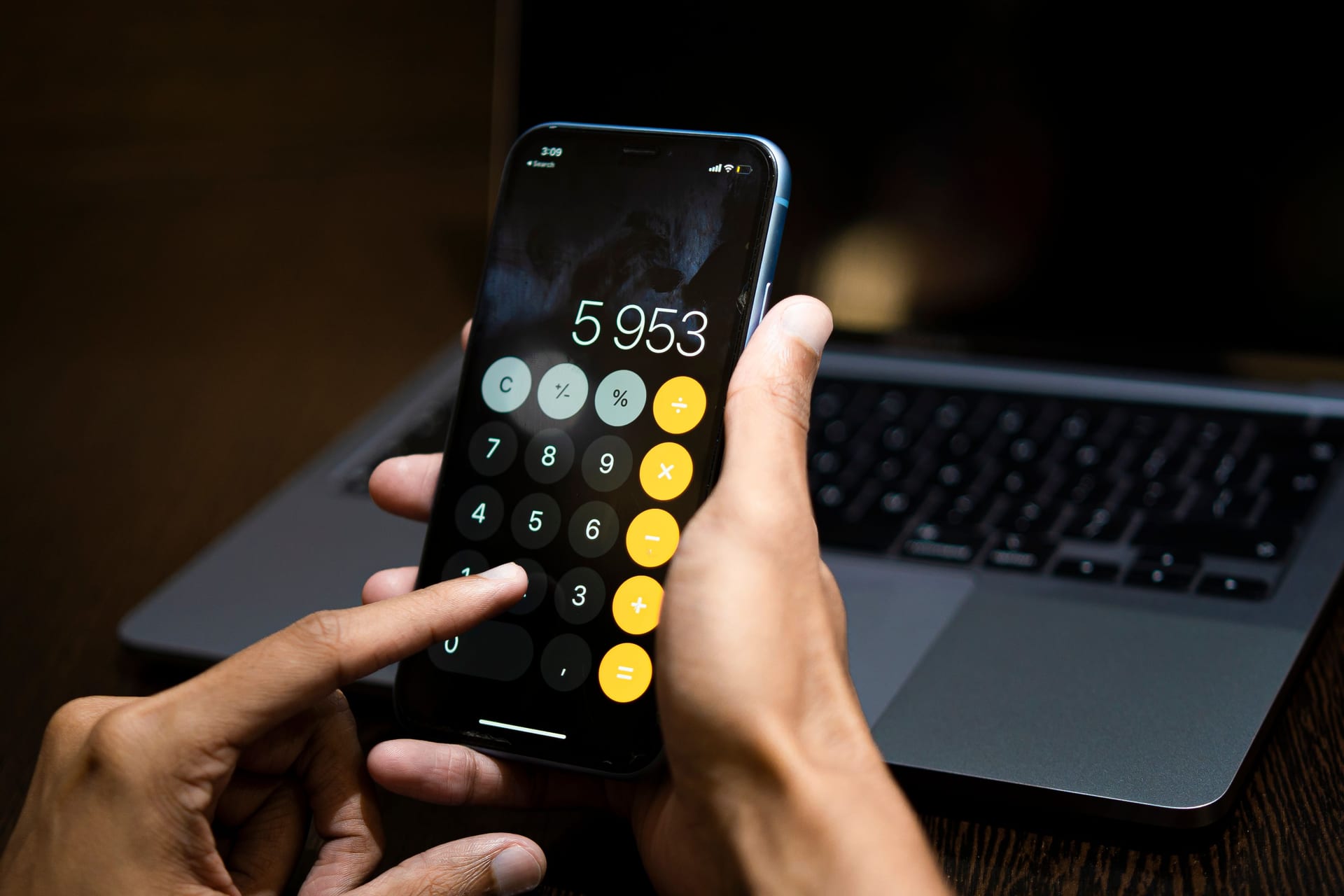 スマートフォンの電卓アプリで計算する手元
